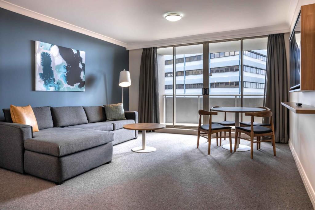 a living room with a couch and a table at Central 1-Bed with Parking, Pool, Sauna & Gym in Sydney