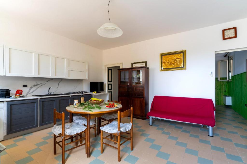 eine Küche mit einem Tisch und einem roten Sofa in der Unterkunft Trilo di Giuseppe 466 in Tricase