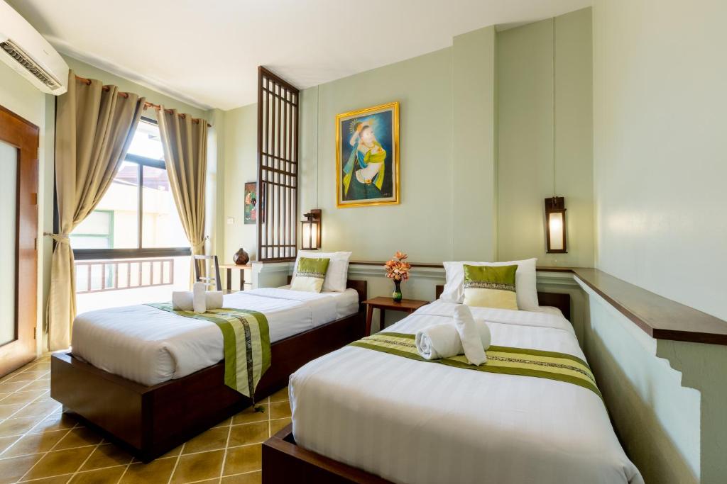 Habitación de hotel con 2 camas y balcón en Huen Hug Chiang Mai, en Chiang Mai