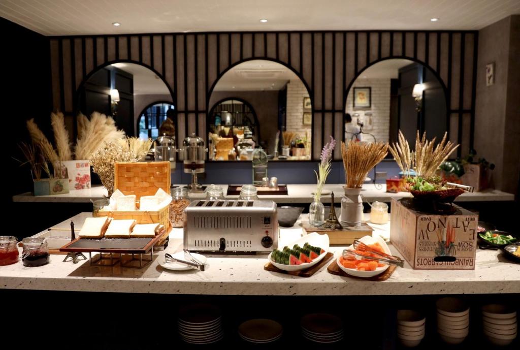 A buffet counter displaying breads, fruit, drinks, and breakfast service equipment.