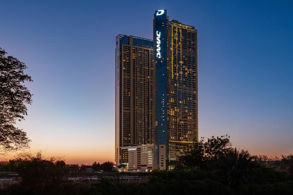 een hoog gebouw met een bord aan de zijkant bij DAMAC Maison Aykon City Dubai in Dubai