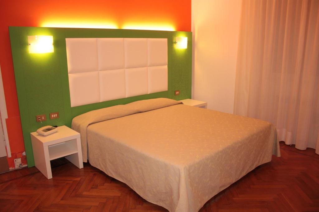 een slaapkamer met een bed en een groene muur bij Affittacamere Via Mazzini in Stresa