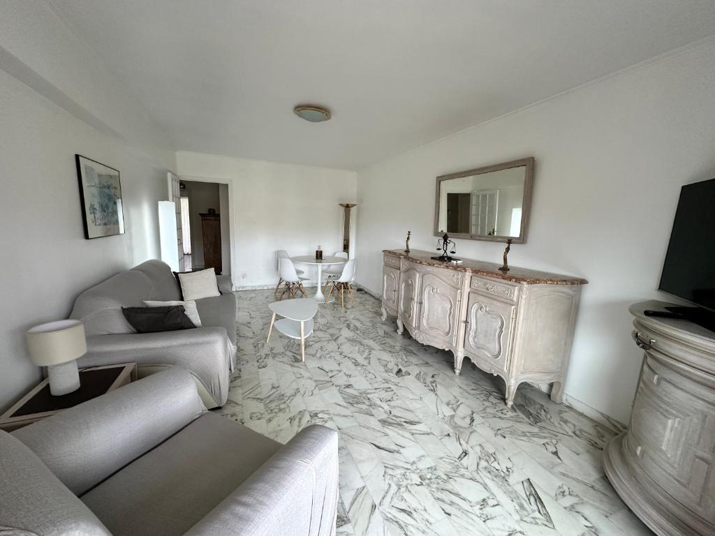 un salon avec un canapé et un miroir dans l'établissement Nice Signature Baumettes, à Nice