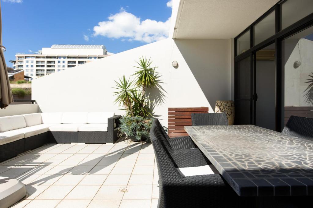 a patio with a table and chairs on a balcony at Chic Unit with Rooftop Terrace near Sights & Shops in Sydney
