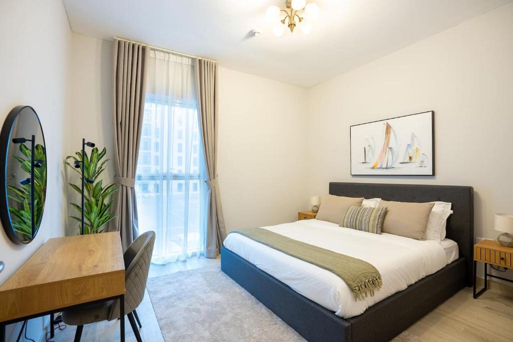 een slaapkamer met een bed, een bureau en een raam bij 1 Bedroom Apartment Yas Island in Abu Dhabi