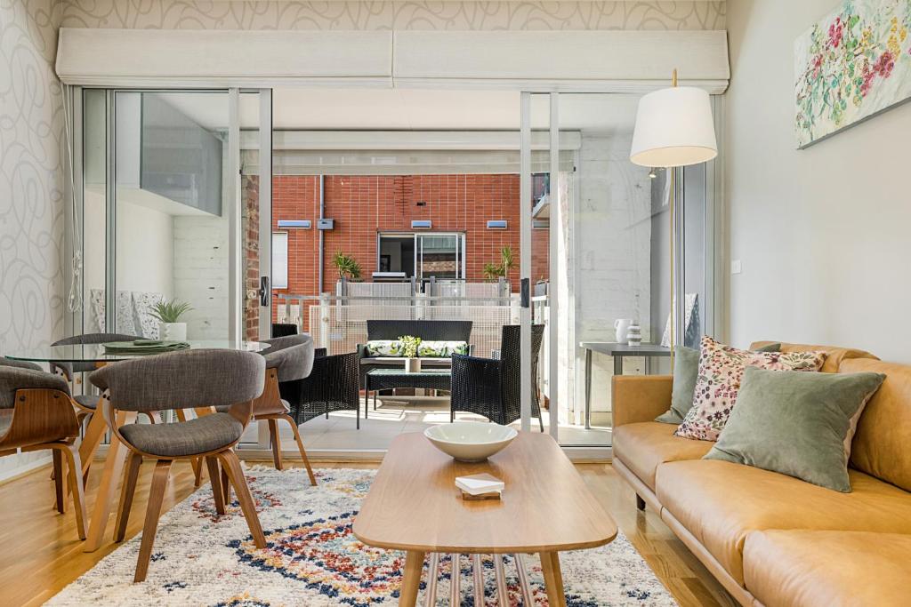 uma sala de estar com um sofá e uma mesa em Designer 2-Bed Unit with Balcony Metres from Beach em Melbourne