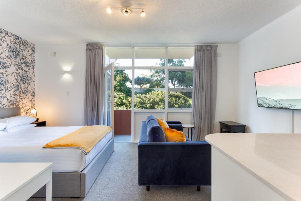 a hotel room with a bed and a large window at Comfy Balcony Studio near Parks, Shopping & Dining in Sydney