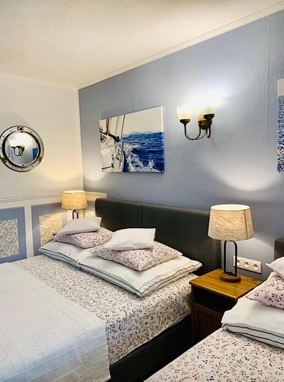 a bedroom with two beds and a picture on the wall at Domek La Pergola in Łeba