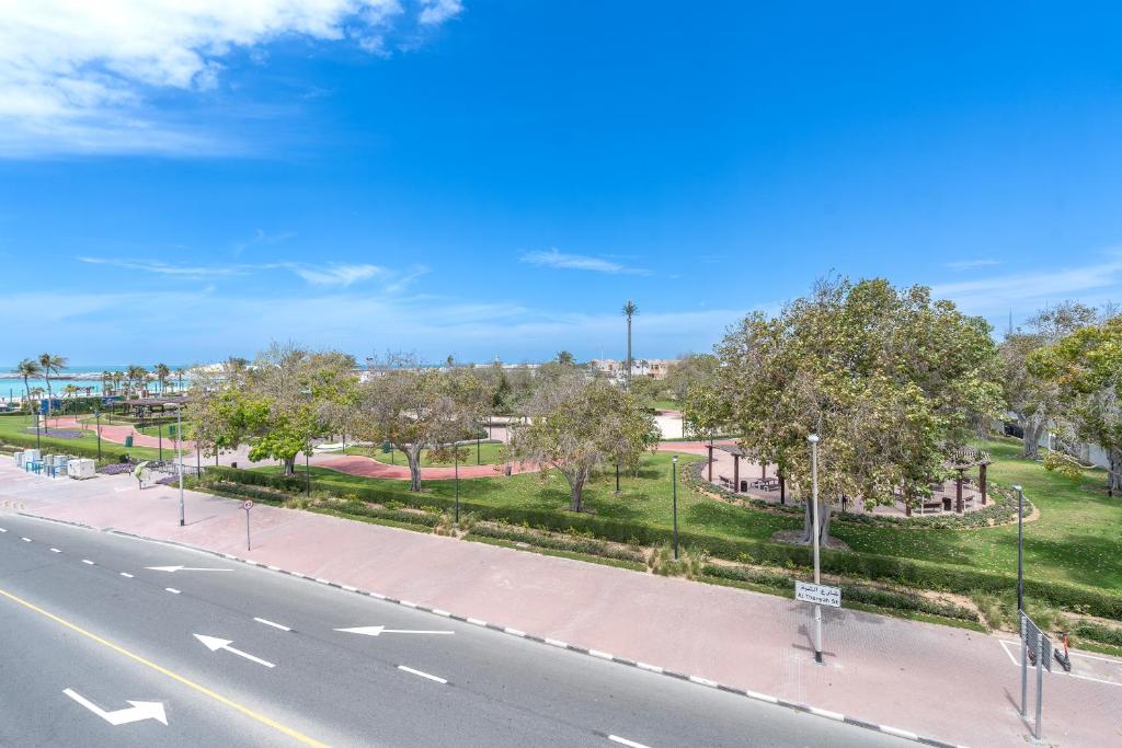 an empty street with trees and a road at Beach Walk Boutique Jumeirah in Dubai