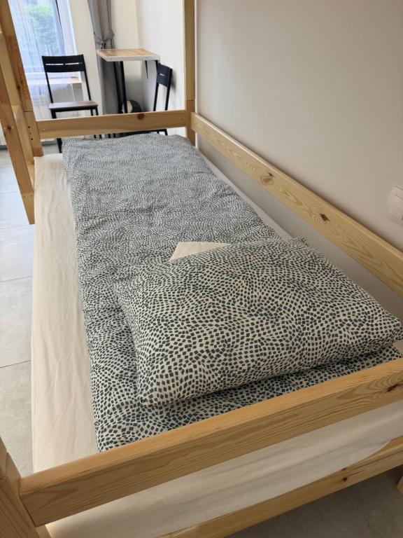 a bed with a wooden frame in a room at Gray Hostel Katowice - Parking in Katowice