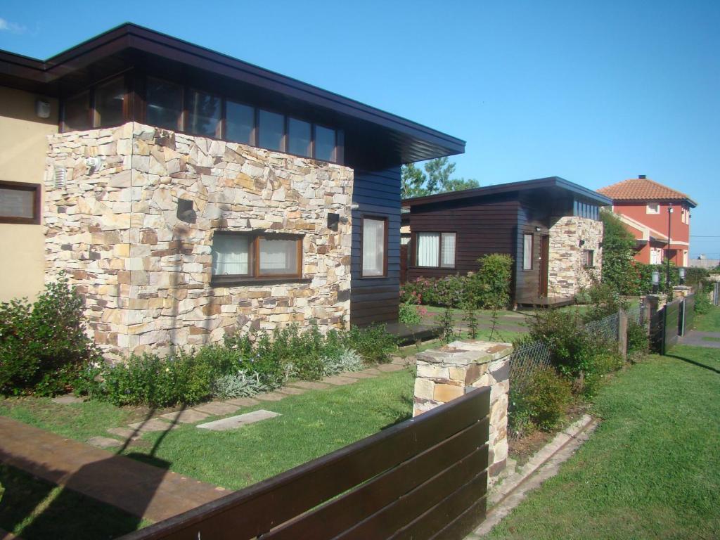 una casa de piedra con una valla delante de ella en Cabañas Klippen en Mar del Plata
