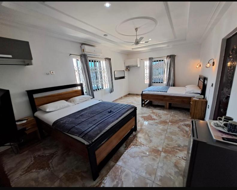 a bedroom with two beds and a television in it at BAFFOUR APARTMENTS in Adiebaba