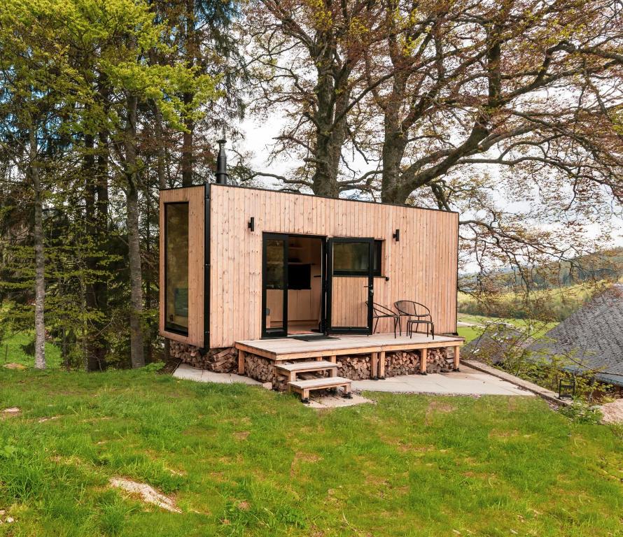 una casita en un campo con un banco en cozy Black Forest Tiny House close to lake, en Schluchsee