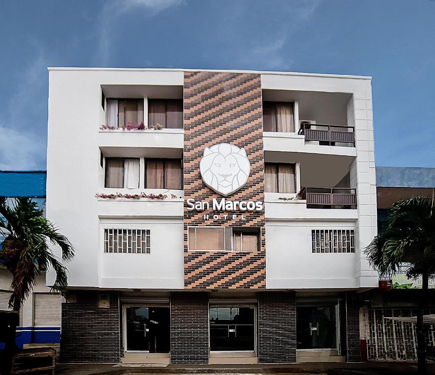 - un bâtiment blanc avec un panneau bleu soleil dans l'établissement Hotel San Marcos Barranquilla, à Barranquilla