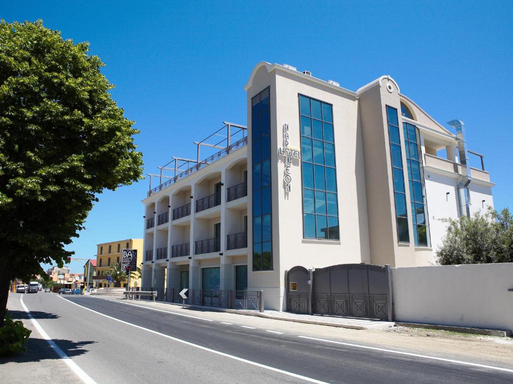 un edificio blanco al lado de una calle en Hotel Napoleon, en Torre Melissa