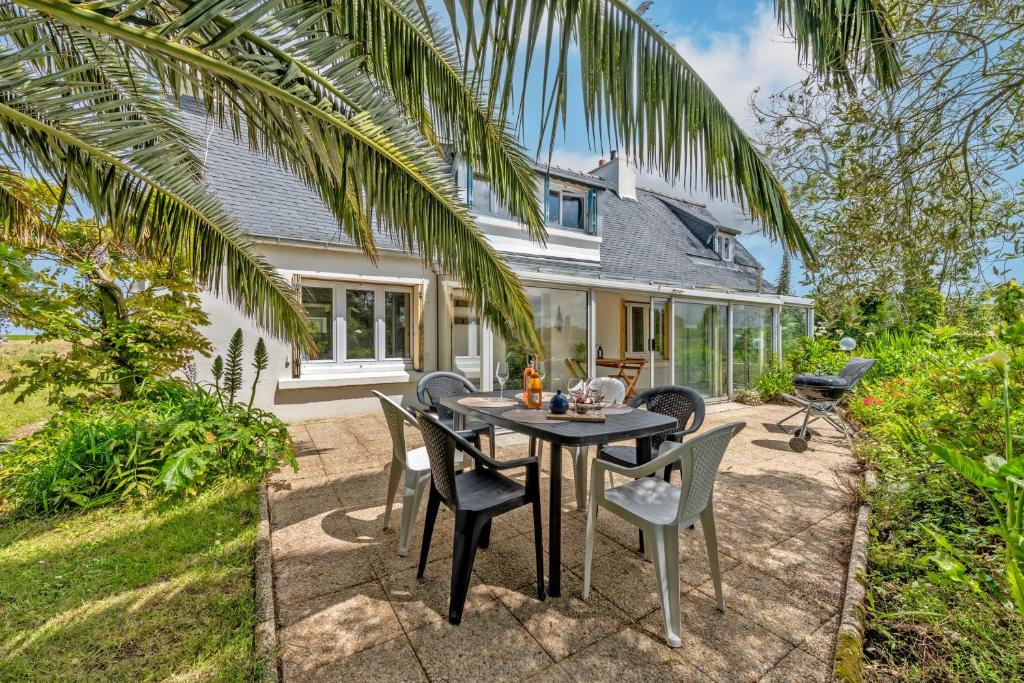 un patio avec une table et des chaises devant une maison dans l'établissement Ty Colo Plougasnou - Longère à 2.5km de la plage, à Plougasnou