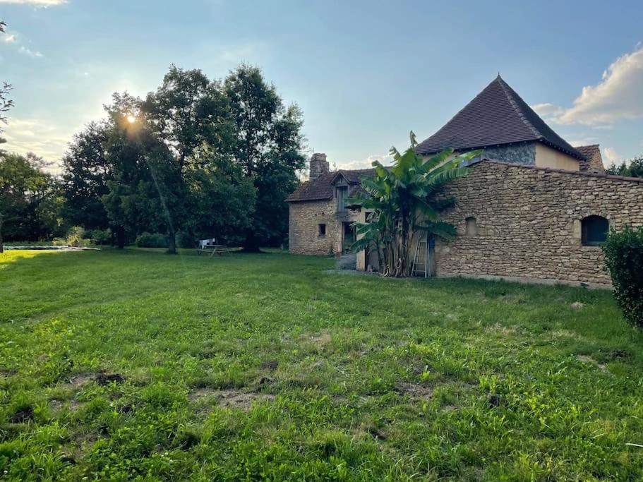an old brick house in a grassy yard at Grande maison type Périgourdine in Montignac