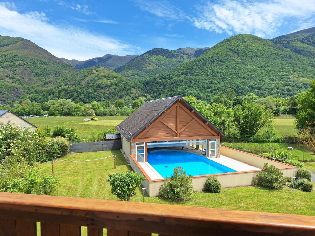 ein Haus mit einem Pool mit Bergen im Hintergrund in der Unterkunft Le Paradis d'ARAN in Luchon