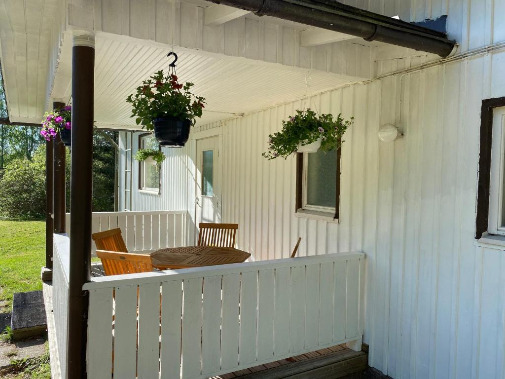 a porch of a white house with chairs and flowers at Villa Siikakoski in Konnevesi