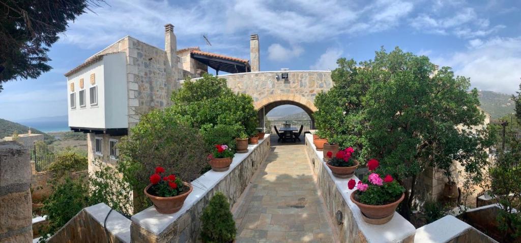 a building with potted plants on a stone wall at TΟRRE DI PIETRA-LUXURY RESIDENCE-ΑMAZING SEA VIEW in Marathón
