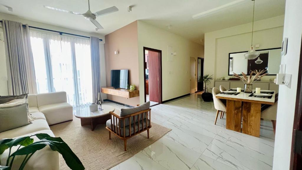 M8 Apartments in Wellawatte في كولومبو: غرفة معيشة مع أريكة وطاولة