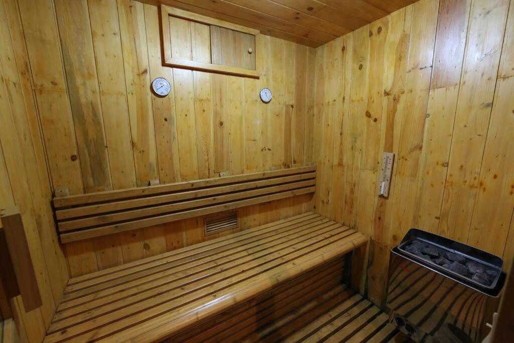 a wooden sauna with a bench in a room at PURI BALI STANIA, Cisarua West Java in Cilama