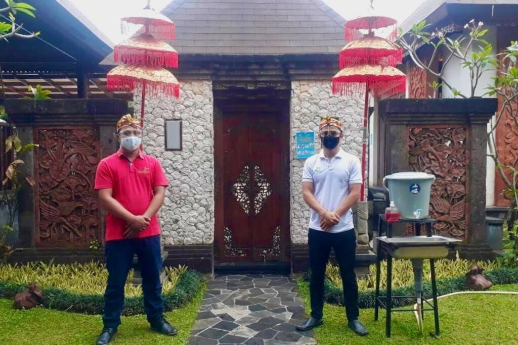 two men wearing masks standing in front of a house at PURI BALI STANIA, Cisarua West Java in Cilama