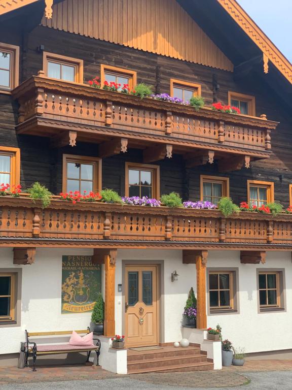 a wooden house with a balcony with flowers on it at Ferienhof Nasnergut in Radstadt