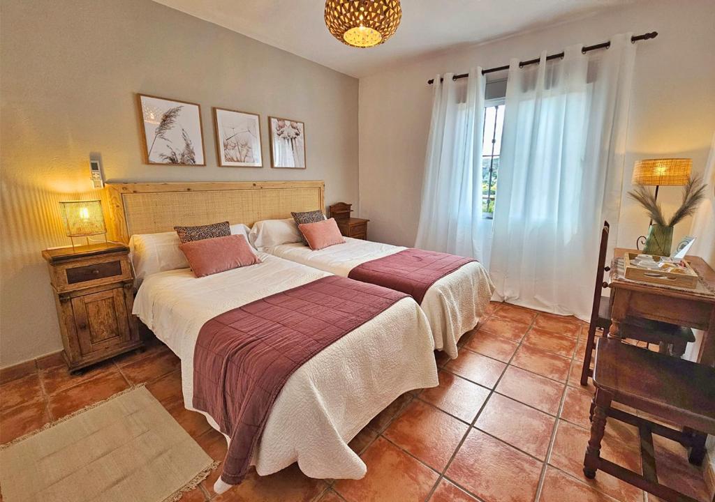 Un dormitorio con dos camas y una ventana. en Los Molinos, en Sanlúcar de Guadiana