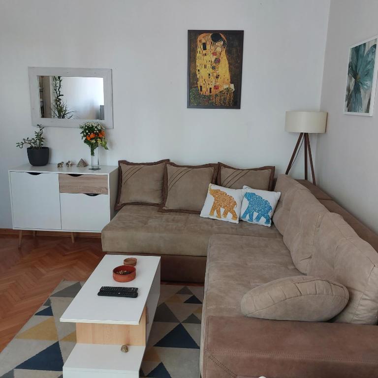a living room with a brown couch and a table at Apartment ADA RB Belgrade in Čukarica