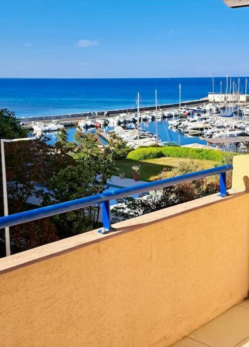 un balcon avec vue sur une marina dans l'établissement Appartement Vue Mer, à Sari-Solenzara