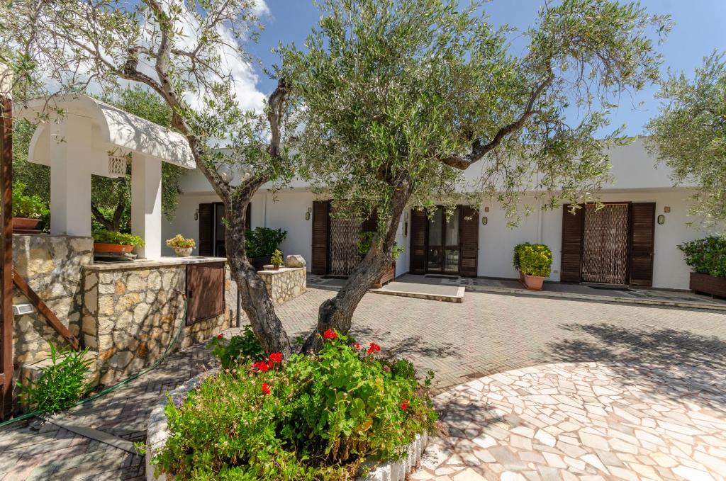 una casa con alberi e fiori in un cortile di Casa I Gabbiani a Mattinata