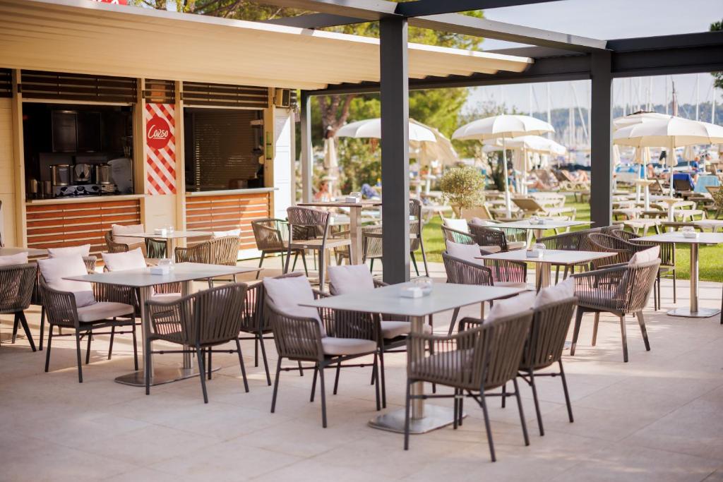 an outdoor patio with tables and chairs and a restaurant at Hotel Neptun - Terme & Wellness Lifeclass in Portorož
