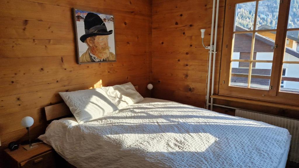 a bedroom with a bed with a hat on the wall at Studio Luizet Nr 28 in Leukerbad