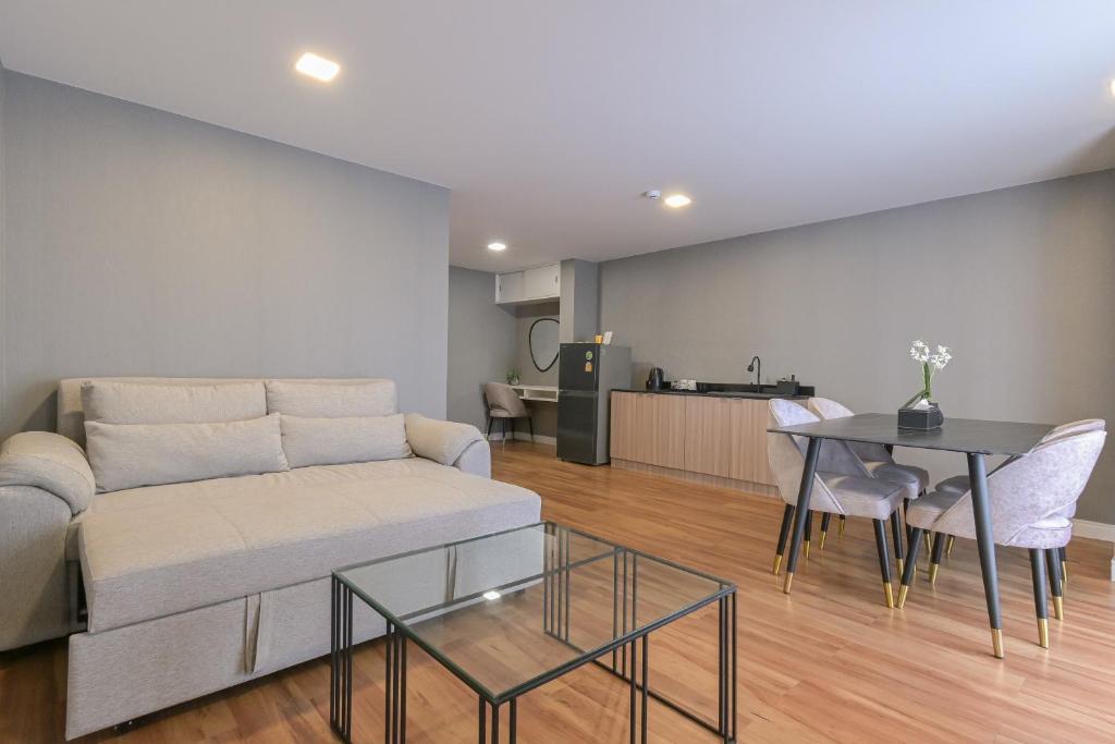 A living room with a full sofa, coffee table and adjoining dining-kitchen area.