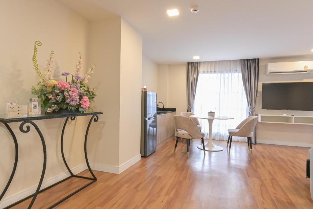 A wide view shows the open-plan living and dining area with a wall-mounted television.