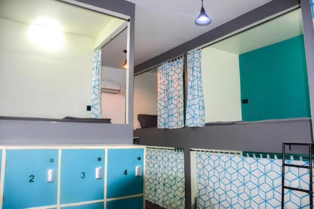 a bathroom with blue cabinets and a mirror at Lost & Found Zanzibar in Zanzibar City