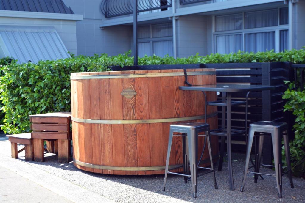 a wooden barrel with a table and two stools at Heartland Ambassador Hotel Hamilton in Hamilton