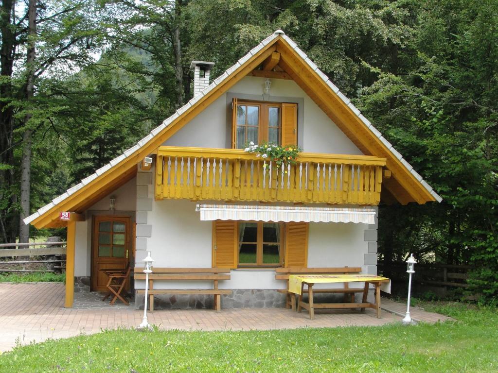 a tiny house with a deck and a picnic table at Holiday House Kaja in Mojstrana