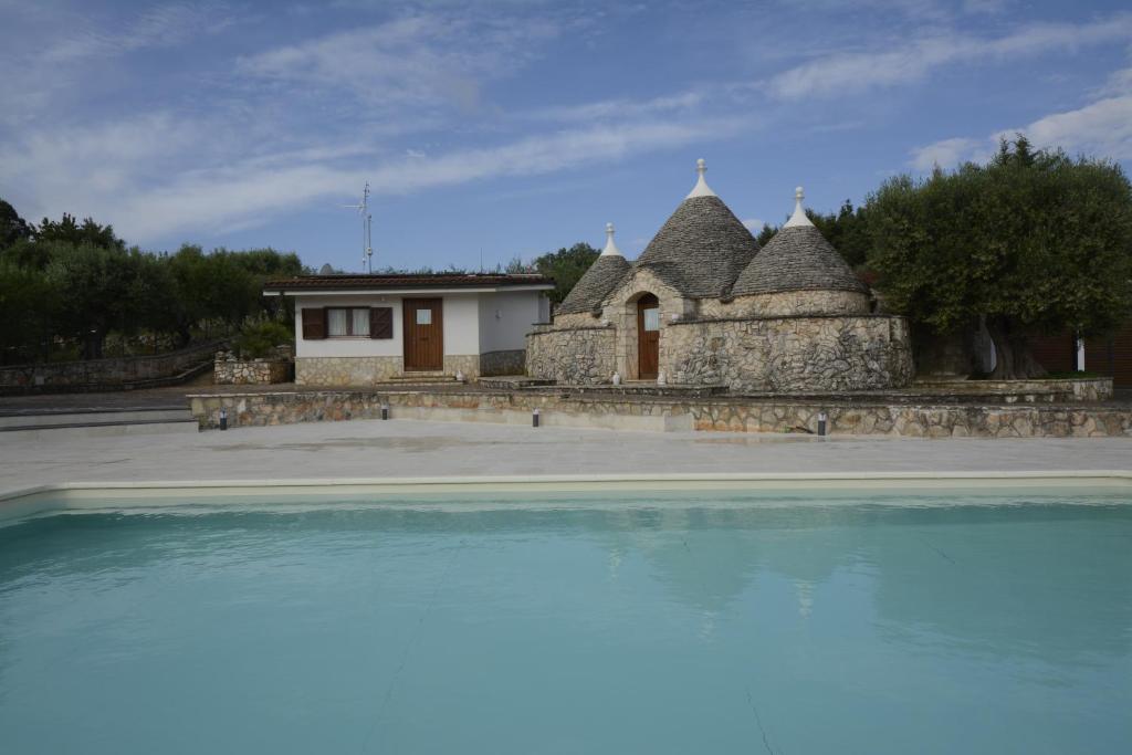 ein großer Pool mit Wasser vor einem Haus in der Unterkunft I trulli di Eva in Noci