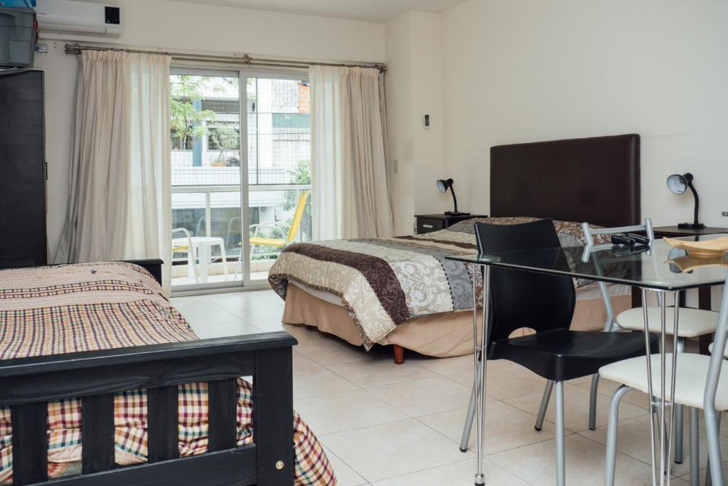 um quarto com uma cama, uma mesa e cadeiras em Darregueyra 2387 em Buenos Aires