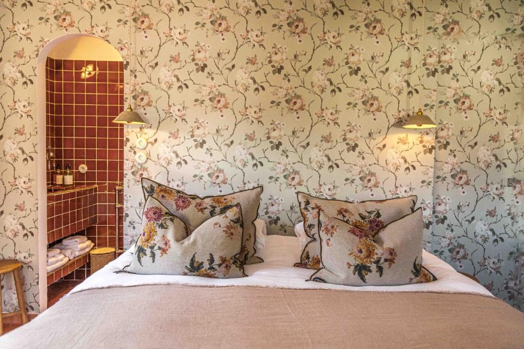 1 dormitorio con 1 cama con papel pintado con motivos florales en Suites 23, en Cassis