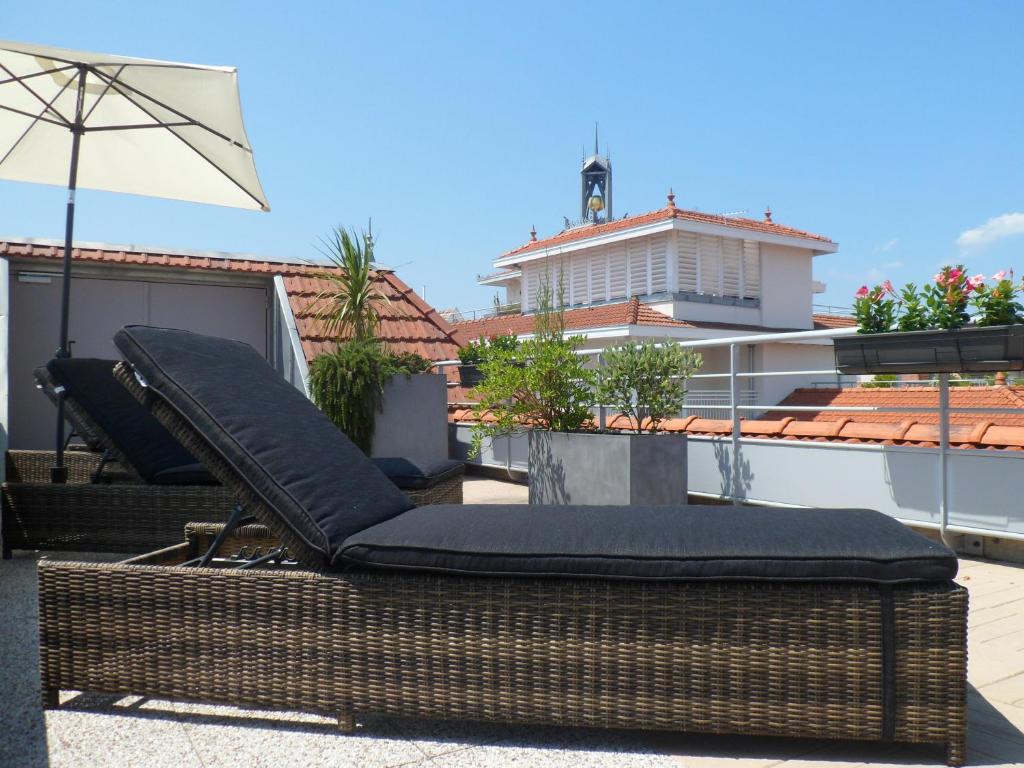 a mattress sitting on a balcony with an umbrella at Residhome Arcachon Plazza in Arcachon