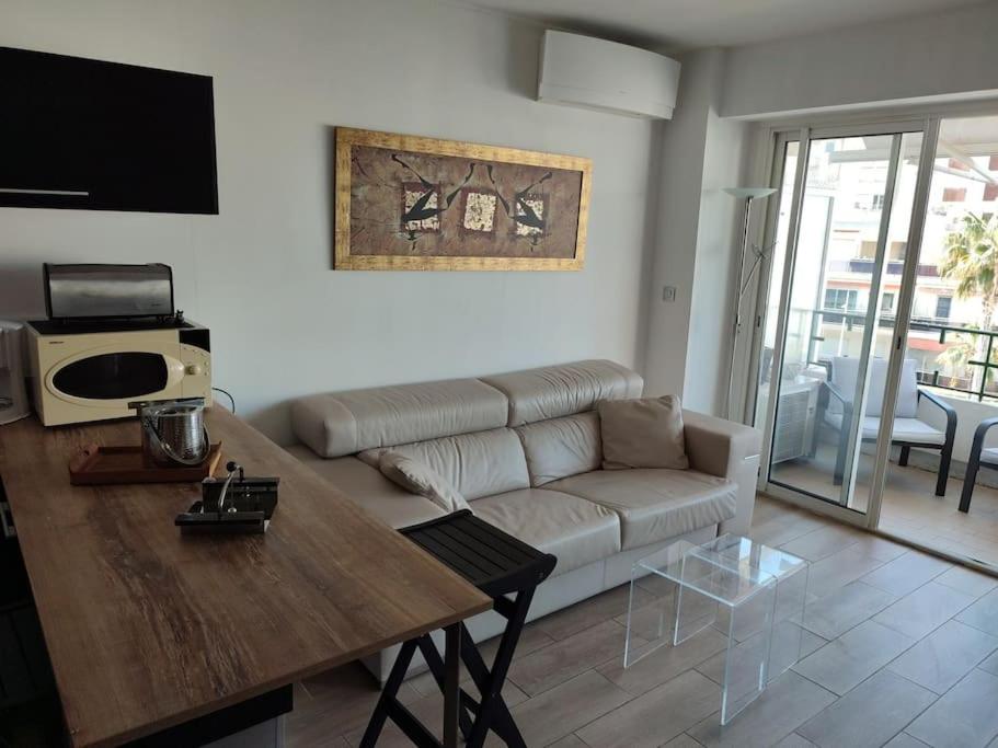 un salon avec un canapé et une table dans l'établissement Studio neuf climatisé au cœur de Juan-les-Pins, à Antibes