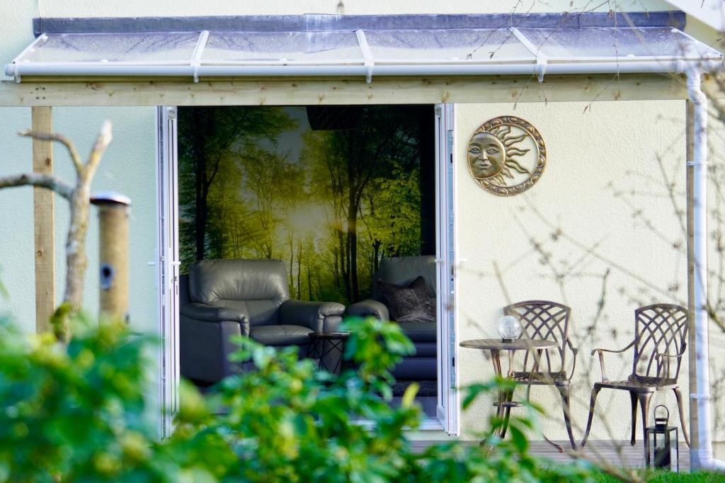 a patio with chairs and a table on a house at Sundial Cottage in Newton Abbot