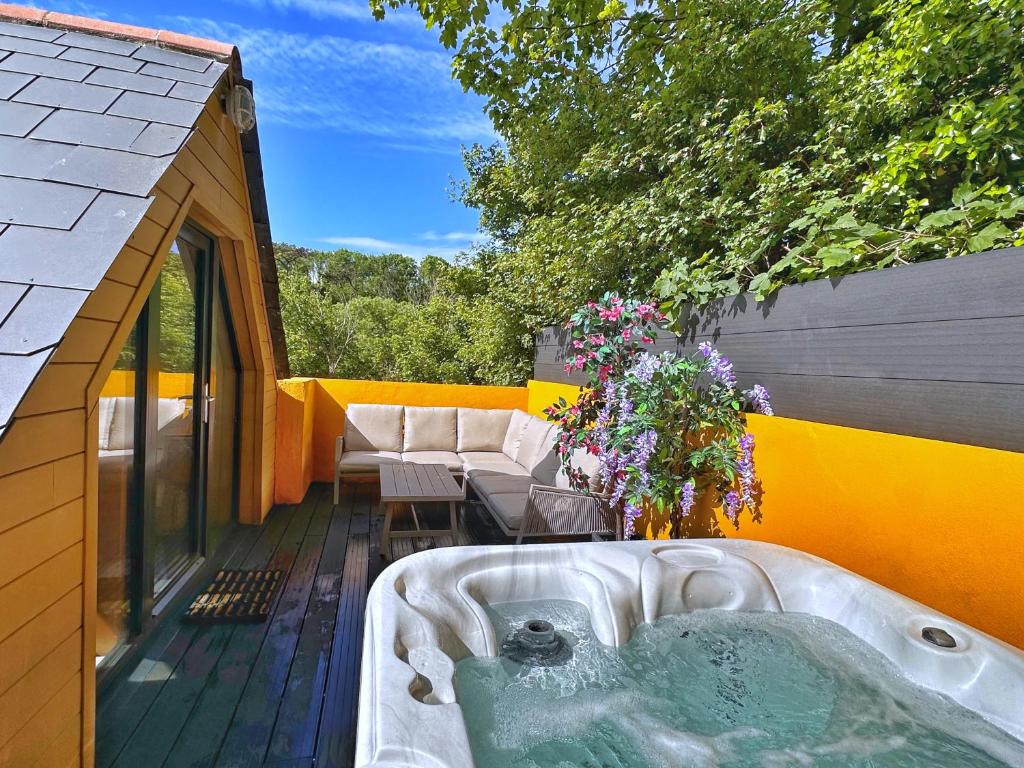 uma banheira de hidromassagem no deque de uma casa em Chy Glynn. Luxury lodge with hot tub and views. em St. Agnes