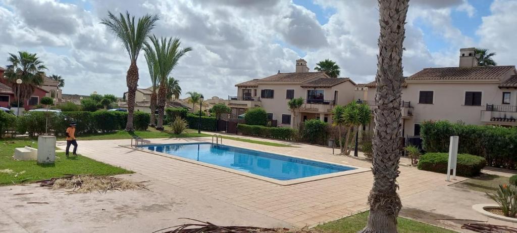 a man standing in front of a house with a swimming pool at HL 009- 2 Bedroom villa,HDA golf resort, Fuente Alamo in Murcia