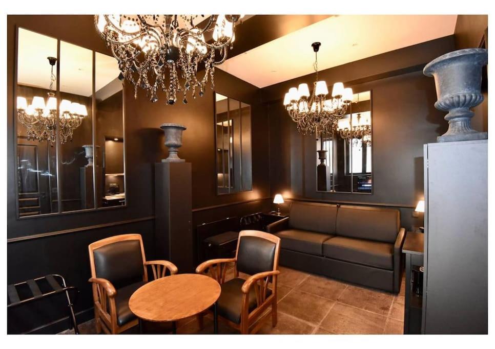 un salon avec un canapé, une table et des chaises dans l'établissement Nice Signature Zone Piétonne, à Nice