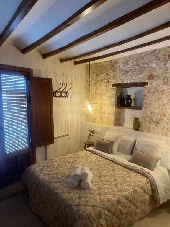een slaapkamer met een groot bed en een stenen muur bij rural-home callemayor in Altura