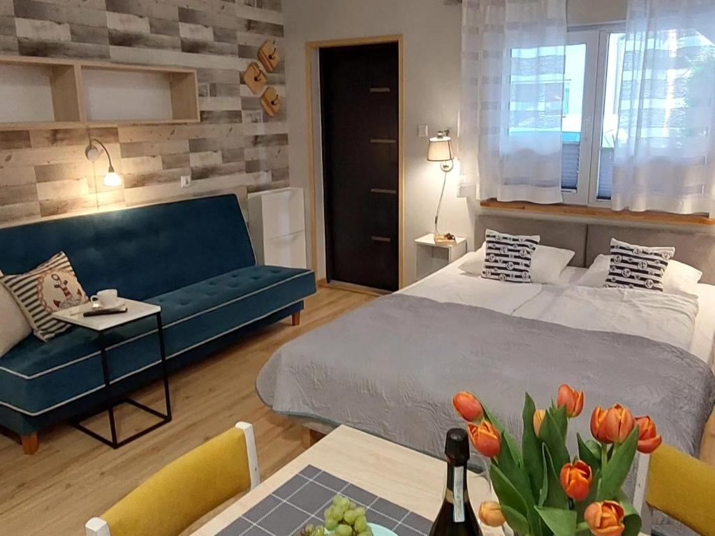 a bedroom with a bed and a couch and a table at Apartamenty i Mieszkania Wakacyjne in Chałupy